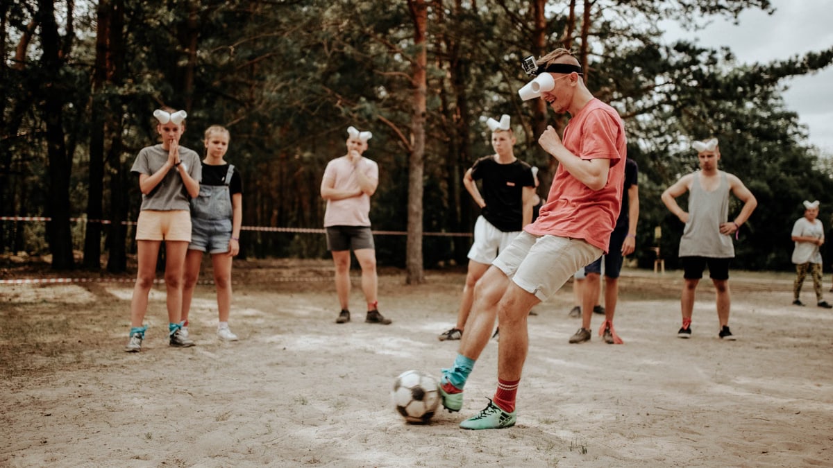 A group of people playing a fun outdoor soccer game wearing funny goggles.